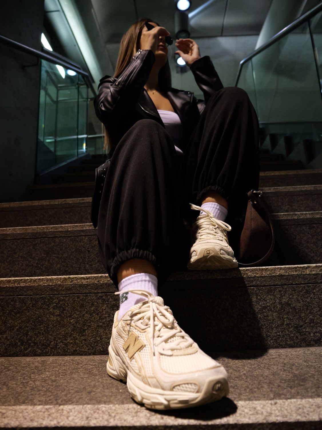 Jovana sitzt auf einer Treppe, der Sneaker ist im Vordergrund